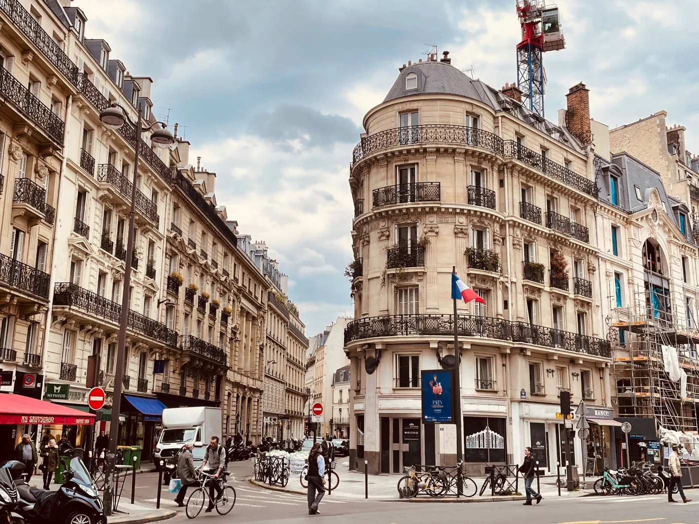 A Paris street framed by classic Haussmann façades and wrought-iron balconies